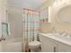 Cozy bathroom featuring a flamingo shower curtain, vanity, mirror and convenient storage at 4942 Blue Heron Dr, New Port Richey, FL 34652