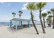 Relaxing beach with palm trees and picnic pavilions with blue accents at 4942 Blue Heron Dr, New Port Richey, FL 34652