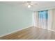 Unfurnished bedroom with wood-look floors and a bright window with curtains at 4942 Blue Heron Dr, New Port Richey, FL 34652