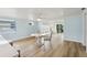Bright dining area featuring hardwood floors and views into the living room and access to the backyard at 4942 Blue Heron Dr, New Port Richey, FL 34652