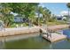 Backyard view shows the lawn, deck with seating, dock and home along the canal at 4942 Blue Heron Dr, New Port Richey, FL 34652