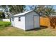 View of a white storage shed in backyard with wooden fence and partial grass area at 5309 Bayonne Ave, Spring Hill, FL 34608