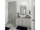 Modern bathroom with a vessel sink, granite countertop, tiled accent wall and modern fixtures at 5328 Baldock Ave, Spring Hill, FL 34608