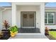 Inviting entryway with double doors adorned with wreaths, flanked by plants and contrasted by dark tile flooring at 5328 Baldock Ave, Spring Hill, FL 34608