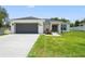 Charming home featuring a well-manicured lawn, gray garage door, and inviting entryway with decorative wreaths at 5328 Baldock Ave, Spring Hill, FL 34608