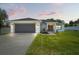 Charming home with a well-manicured lawn, gray garage door, and inviting entryway featuring decorative wreaths at 5328 Baldock Ave, Spring Hill, FL 34608