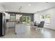 Modern kitchen featuring grey cabinets, granite countertops, an island, and stainless steel appliances with an adjacent dining area at 5328 Baldock Ave, Spring Hill, FL 34608
