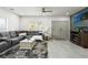Bright living room features a plush gray sofa, stylish rug, and double doors, creating a cozy atmosphere at 5328 Baldock Ave, Spring Hill, FL 34608