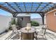 Relaxing backyard patio with a rustic pergola, stylish outdoor furniture, and a cozy gas fire pit at 5330 Dove Dr, New Port Richey, FL 34652