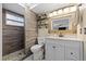Modern bathroom featuring a walk-in shower with stone flooring and a custom vanity with shelving at 5330 Dove Dr, New Port Richey, FL 34652
