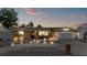 Exterior shot of a well lit single-story home featuring meticulous landscaping and welcoming front porch at twilight at 5330 Dove Dr, New Port Richey, FL 34652
