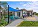 Backyard patio showcasing stylish outdoor seating, a sunshade, and mature landscaping, creating a tranquil retreat at 5340 Pilots Pl, New Port Richey, FL 34652