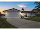 Charming home with white brick, double blue doors, manicured lawn and attached garage at 5340 Pilots Pl, New Port Richey, FL 34652
