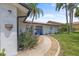 Close up of the front of a charming home with a beautifully landscaped walkway and blue doors at 5340 Pilots Pl, New Port Richey, FL 34652