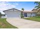 Welcoming single-story home with a two-car garage, and lush landscaping enhancing its curb appeal at 5340 Pilots Pl, New Port Richey, FL 34652