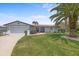 Well-maintained lawn, mature palm trees, and a two-car garage enhancing this home's curb appeal at 5340 Pilots Pl, New Port Richey, FL 34652