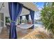 Outdoor patio featuring a relaxing hammock, comfortable seating area, and views of the pool and surrounding landscape at 5340 Pilots Pl, New Port Richey, FL 34652