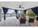 Beautiful outdoor patio showcases comfortable seating, stylish curtains, and a serene view of the pool and canal at 5340 Pilots Pl, New Port Richey, FL 34652