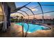 Inviting screened-in pool with waterfront views, lush landscaping, and relaxing patio furniture at 5340 Pilots Pl, New Port Richey, FL 34652