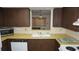 Functional kitchen featuring laminate countertops, white appliances and dark wooden cabinetry with ample storage at 5636 Dolores Dr, Holiday, FL 34690