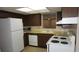 Functional kitchen featuring laminate countertops, white appliances and dark wooden cabinetry with ample storage at 5636 Dolores Dr, Holiday, FL 34690