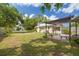 A large backyard featuring a seating area, a garage, and beautiful lush grass at 6207 Main St, New Port Richey, FL 34653