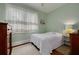 Light green bedroom with hardwood floors and white bedding at 6207 Main St, New Port Richey, FL 34653