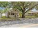 Charming bungalow with a welcoming front porch and mature tree, offering shade and curb appeal at 6207 Main St, New Port Richey, FL 34653