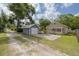 Charming home exterior with gray detached garage and driveway, plus a cozy front porch at 6207 Main St, New Port Richey, FL 34653