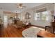 Bright living room featuring hardwood floors, natural light, and open access to the dining area and kitchen at 6207 Main St, New Port Richey, FL 34653
