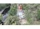 Aerial view of home nestled amongst mature trees along a picturesque river at 6234 Cyril Dr, Dade City, FL 33523