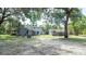 Spacious backyard featuring the main house, a detached guest house, a fire pit, and mature trees at 6234 Cyril Dr, Dade City, FL 33523