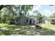 Two-story home with mature trees, featuring a backyard with fire pit, offering a serene outdoor space at 6234 Cyril Dr, Dade City, FL 33523
