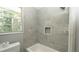 Bathroom showing tiled walls around the bathtub and a shower with a built-in niche at 6234 Cyril Dr, Dade City, FL 33523