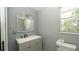 Bathroom featuring a double sink vanity, mirror, toilet, and natural light at 6234 Cyril Dr, Dade City, FL 33523