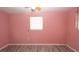 Bedroom with wood-look floors and a window for natural light with bare pink walls at 6234 Cyril Dr, Dade City, FL 33523