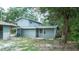 Home's back exterior features a covered patio and mature trees, blending nature and comfort at 6234 Cyril Dr, Dade City, FL 33523