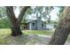 Charming home with grey brick chimney and covered patio, surrounded by mature trees at 6234 Cyril Dr, Dade City, FL 33523