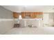 Kitchen features white floors, wood cabinets, window, and stainless-steel double-bowl sink, needs renovation at 6234 Cyril Dr, Dade City, FL 33523