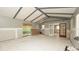 Living room with tall ceilings featuring new floors, bare drywall, sliding doors, and beamed ceilings at 6234 Cyril Dr, Dade City, FL 33523