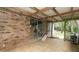 Spacious covered patio with brick wall and sliding glass door, offering outdoor living space at 6234 Cyril Dr, Dade City, FL 33523