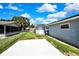 This backyard boasts a concrete pad, green grass, wooden fence, and an extra outbuilding with solar panels at 6306 Aberdeen Ave, New Port Richey, FL 34653