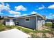 Image of the backyard, showcasing a concrete pad, green grass, wooden fence, and an extra outbuilding at 6306 Aberdeen Ave, New Port Richey, FL 34653