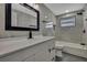 This renovated bathroom boasts marble style tile walls, a large vanity, and modern black fixtures and hardware at 6306 Aberdeen Ave, New Port Richey, FL 34653