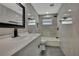 Modern bathroom with marble tile, white vanity, and updated fixtures at 6306 Aberdeen Ave, New Port Richey, FL 34653