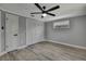 Bedroom with light grey walls, a ceiling fan, and wood-look flooring at 6306 Aberdeen Ave, New Port Richey, FL 34653