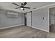 Cozy bedroom featuring light wood flooring and sliding barn door at 6306 Aberdeen Ave, New Port Richey, FL 34653