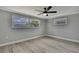 Bedroom featuring light gray walls, wood-look flooring, and natural light through the windows at 6306 Aberdeen Ave, New Port Richey, FL 34653