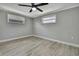 Neutral bedroom featuring wood-look floors, fresh grey paint, white trim and a ceiling fan at 6306 Aberdeen Ave, New Port Richey, FL 34653