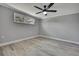 Bright bedroom featuring wood-look flooring, neutral walls, and a modern ceiling fan at 6306 Aberdeen Ave, New Port Richey, FL 34653
